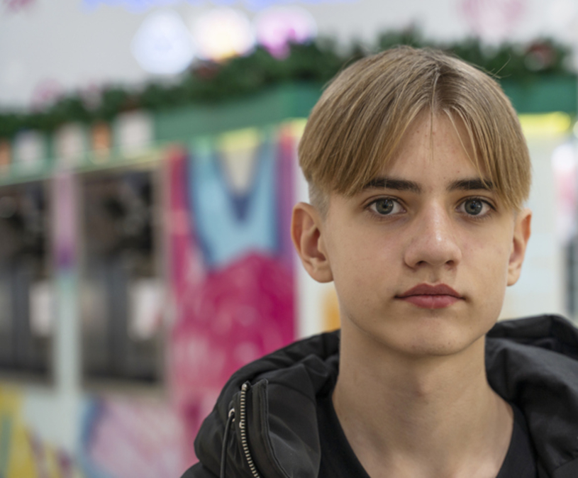 jongen op straat kijkt strak de camera in