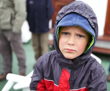 jongetje met capuchon op kijkt boos