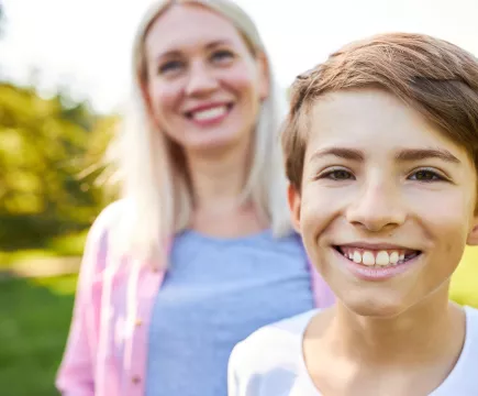 jongen met moeder op de achtergrond